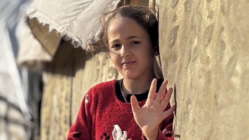 A smiling girl waving